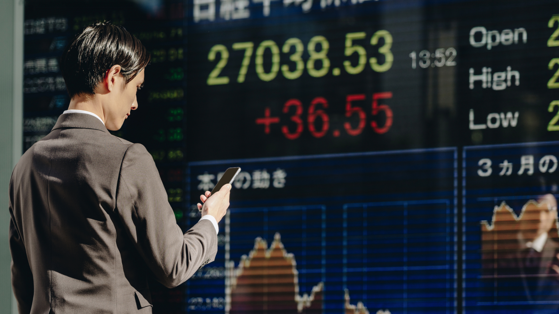 japanese man looks concerned at stock exchange